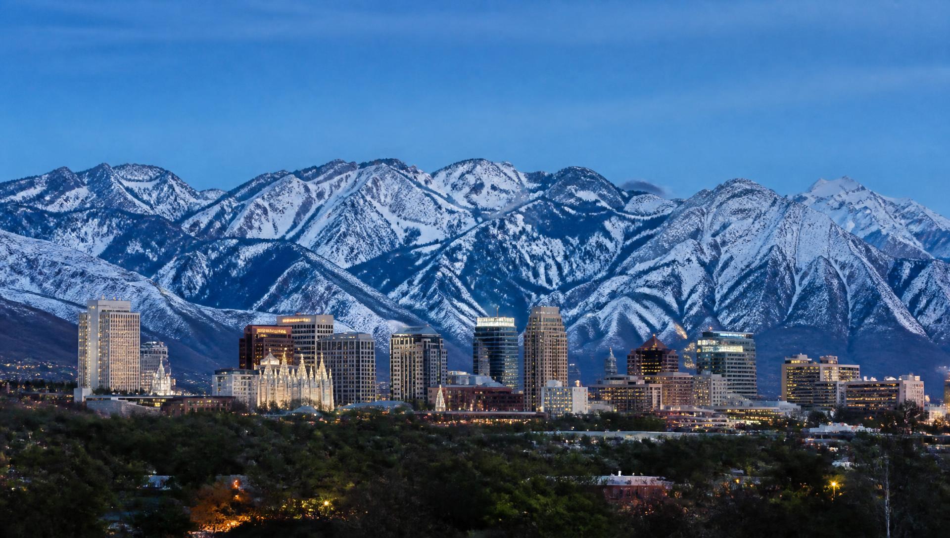 The downtown Salt Lake City skyline below the snow-capped Wasatch Range in warm terracotta duotone